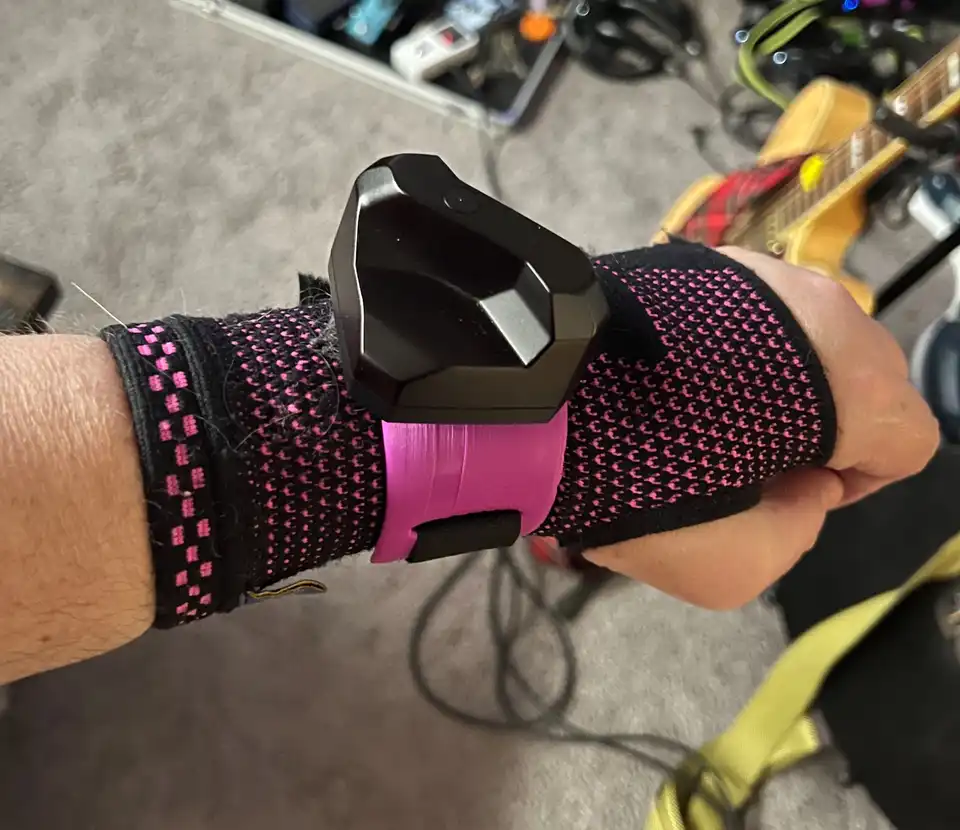 A human forearm wearing a compression sleeve and a Tundra tracker on a 3D-printed wrist mount